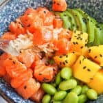 Close up of a forkful of salmon in a salmon poke bowl