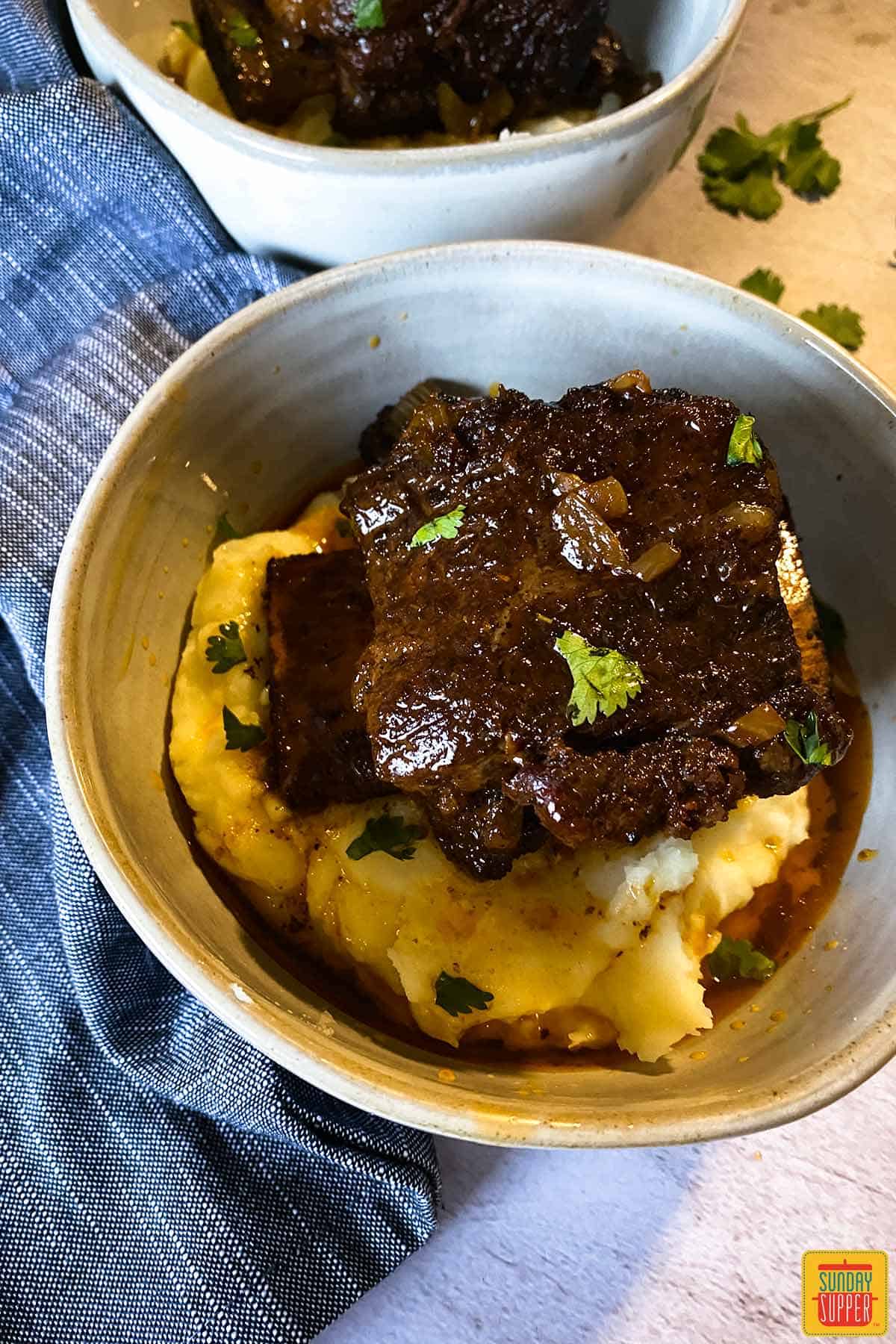 Beef short ribs in a bowl over mashed potatoes