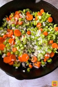 Vegetables in cast iron skillet: carrots, celery, onion