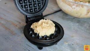 Spoonful of banana waffles batter in the center of a mini waffle maker