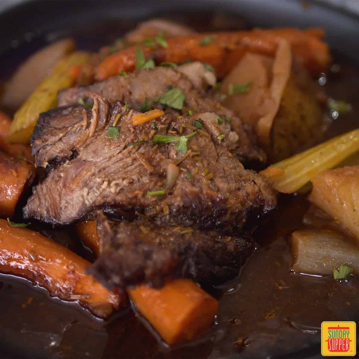 Chuck roast up close with vegetables and gravy