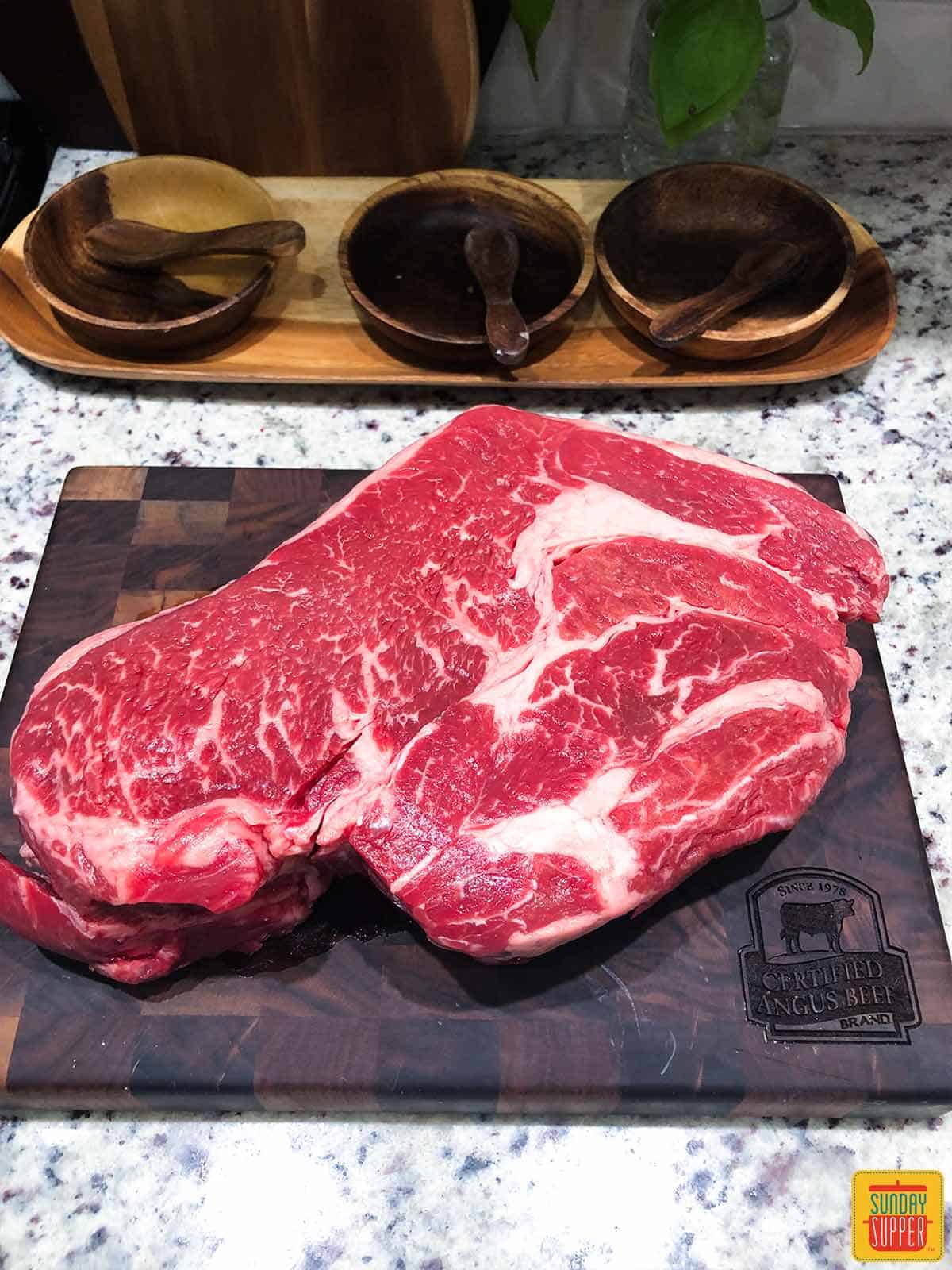 Beautifully marbled beef chuck roast on a cutting board