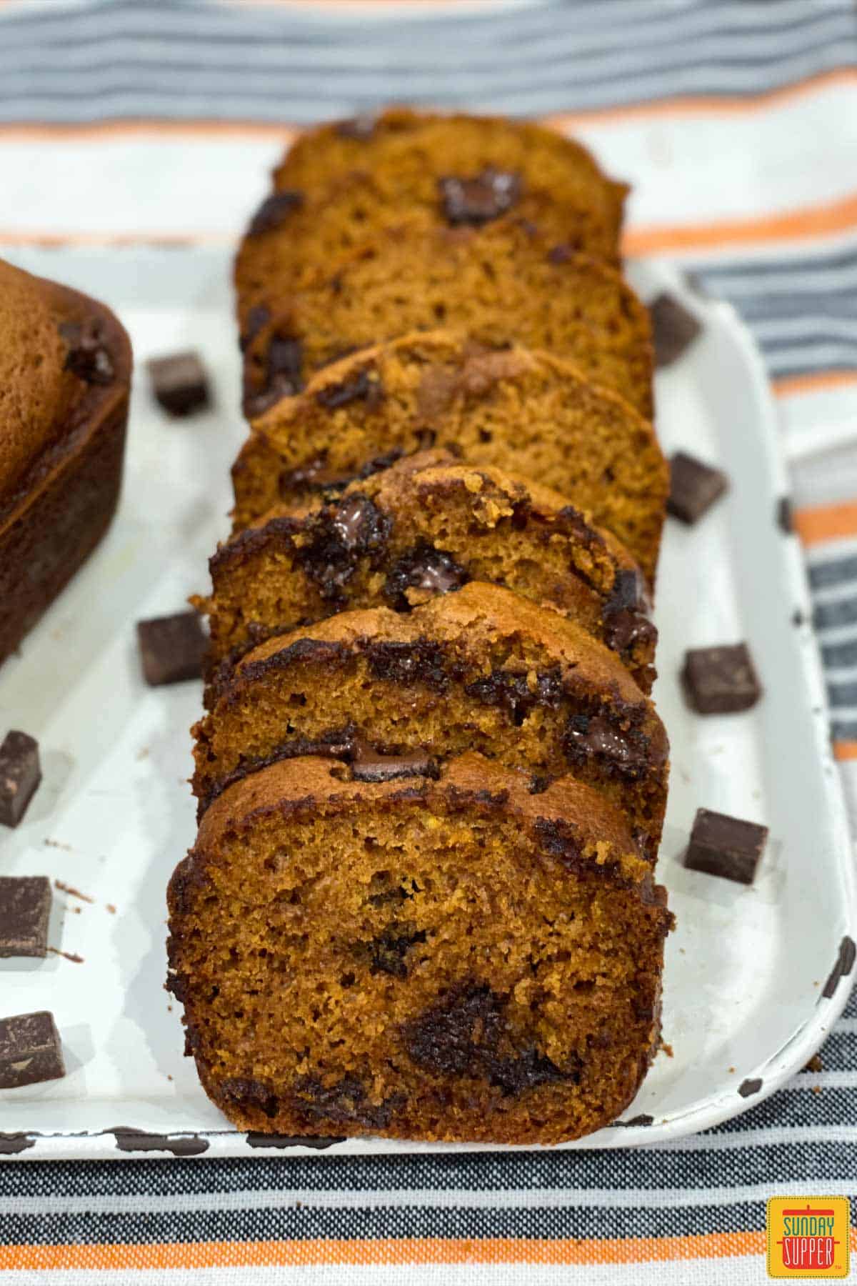 Slices of chocolate chip pumpkin bread on a white platter