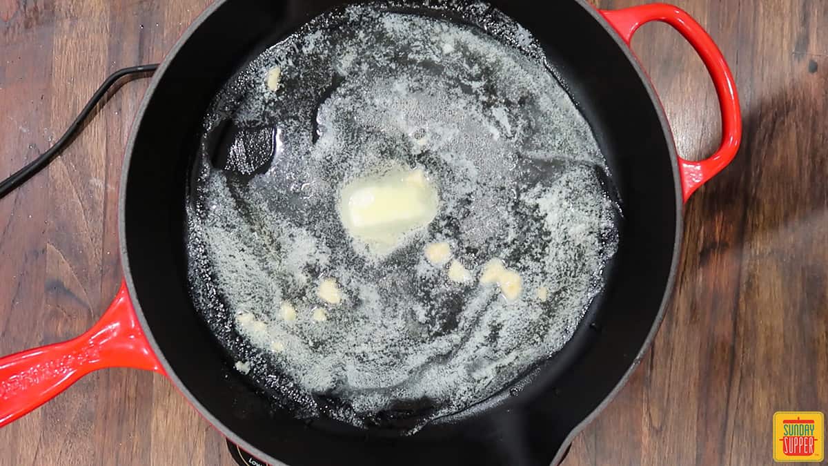 Melting butter and cooking garlic in a skillet