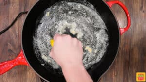 Squeezing lemon into a skillet with garlic and butter