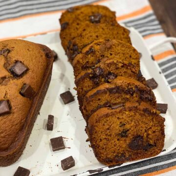 Slices of instant pot pumpkin chocolate chip bread next to a full loaf