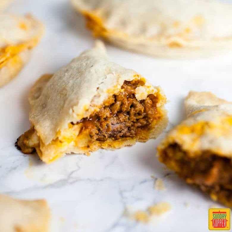 close up of puerto rican beef empanadas in half to show filling