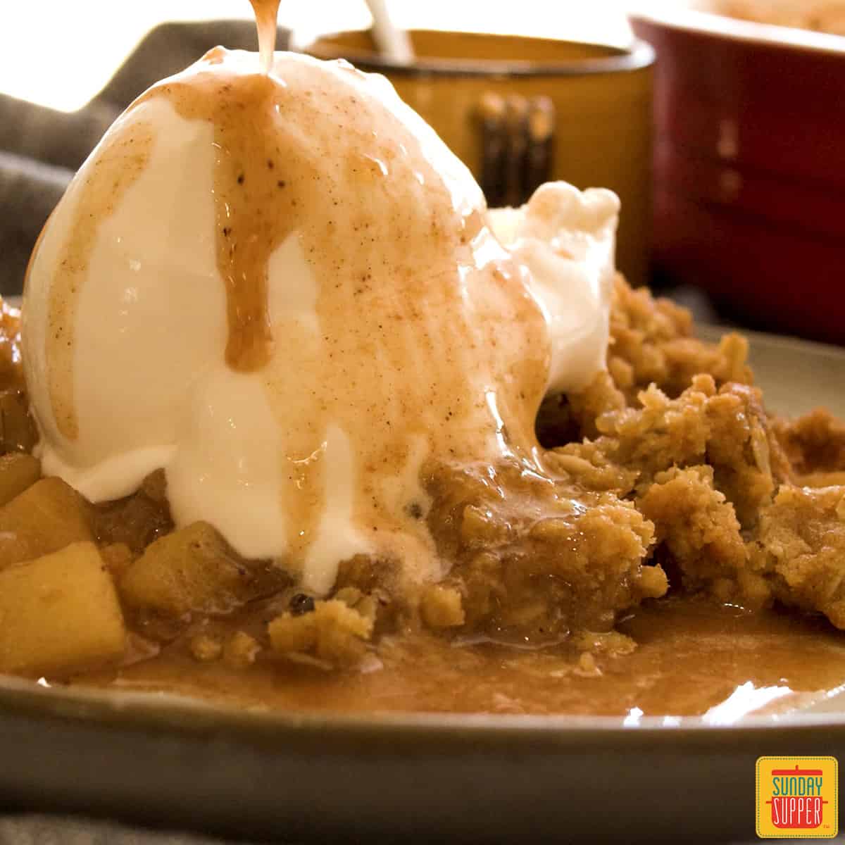 Ice cream melting over the top of a slice of apple crisp