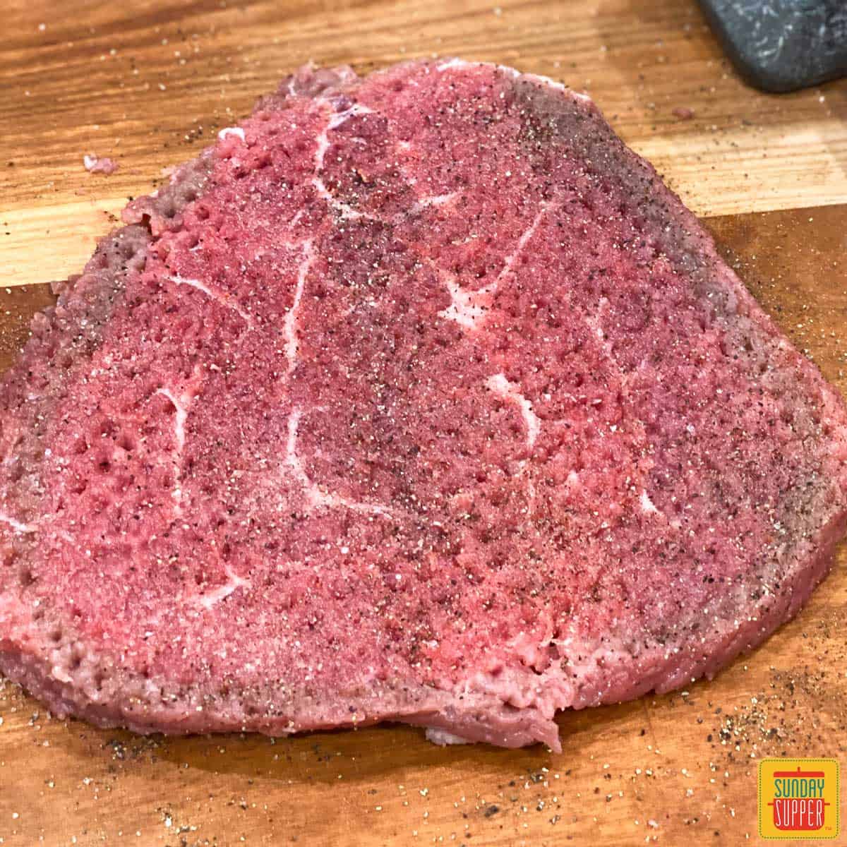 Tenderized steak on a cutting board