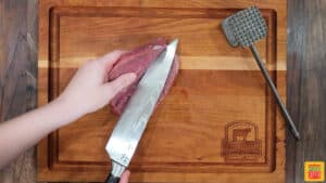 beginning to open the steak with the knife after cutting through it