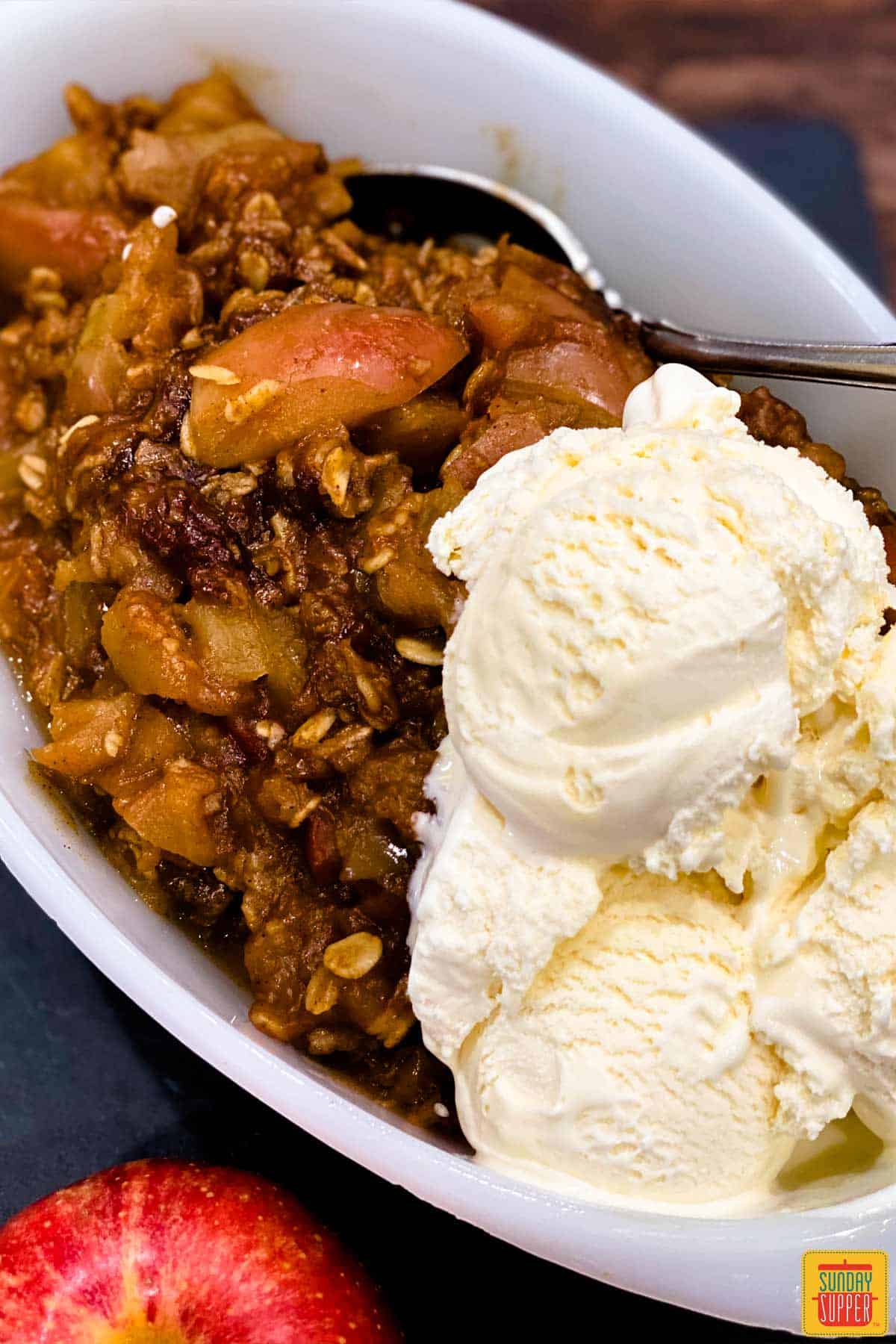 Instant pot apple crisp in a white dish with ice cream