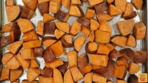 Close up of sweet potatoes on baking sheet ready to be baked