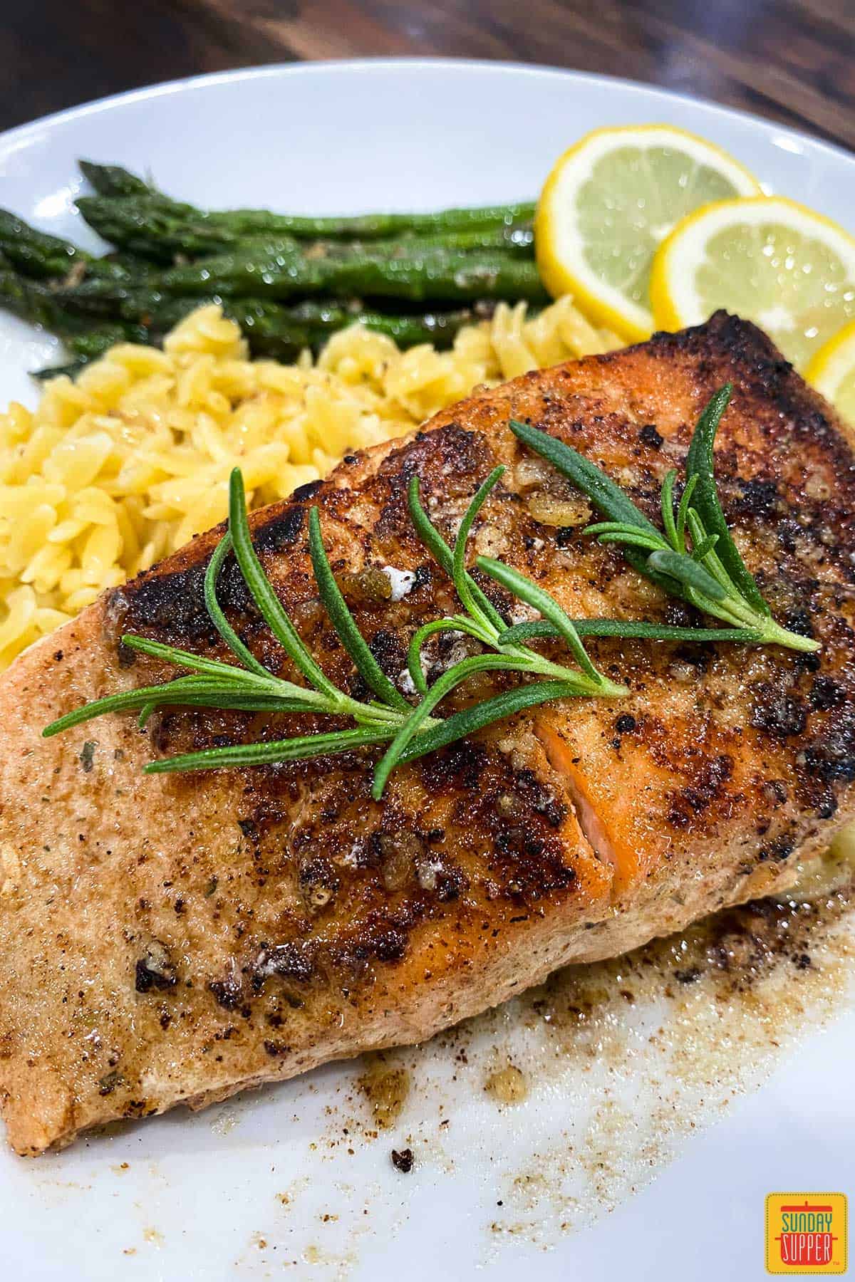 Close up of a sous vide salmon with fresh rosemary sprigs on top