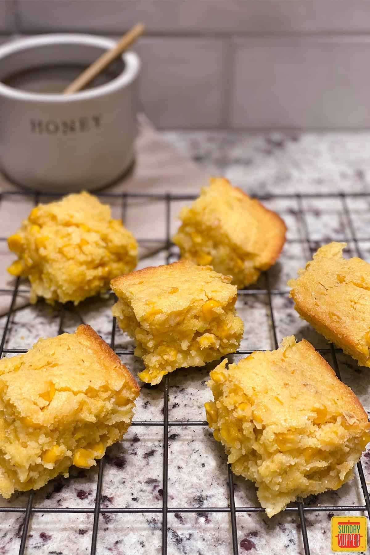 Squares of baked creamed corn casserole on a rack