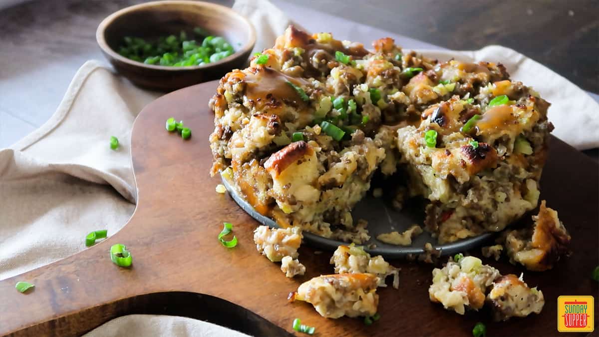 Close up of instant pot sausage sage stuffing on a wooden board topped with parsley