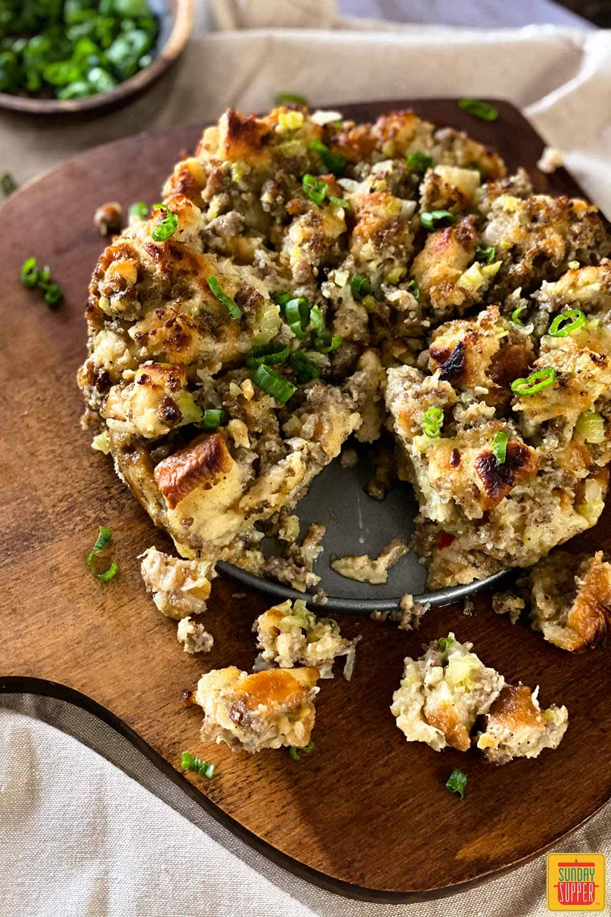 Sage sausage stuffing on a wooden board with a piece missing