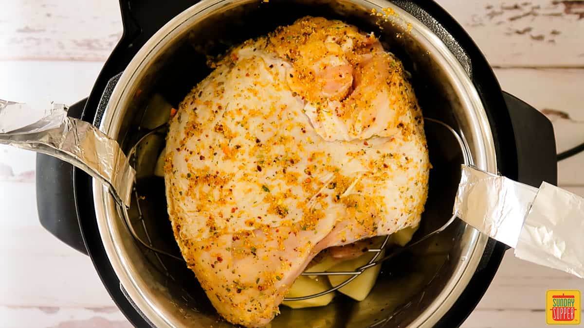 Turkey placed over the trivet in the instant pot before cooking