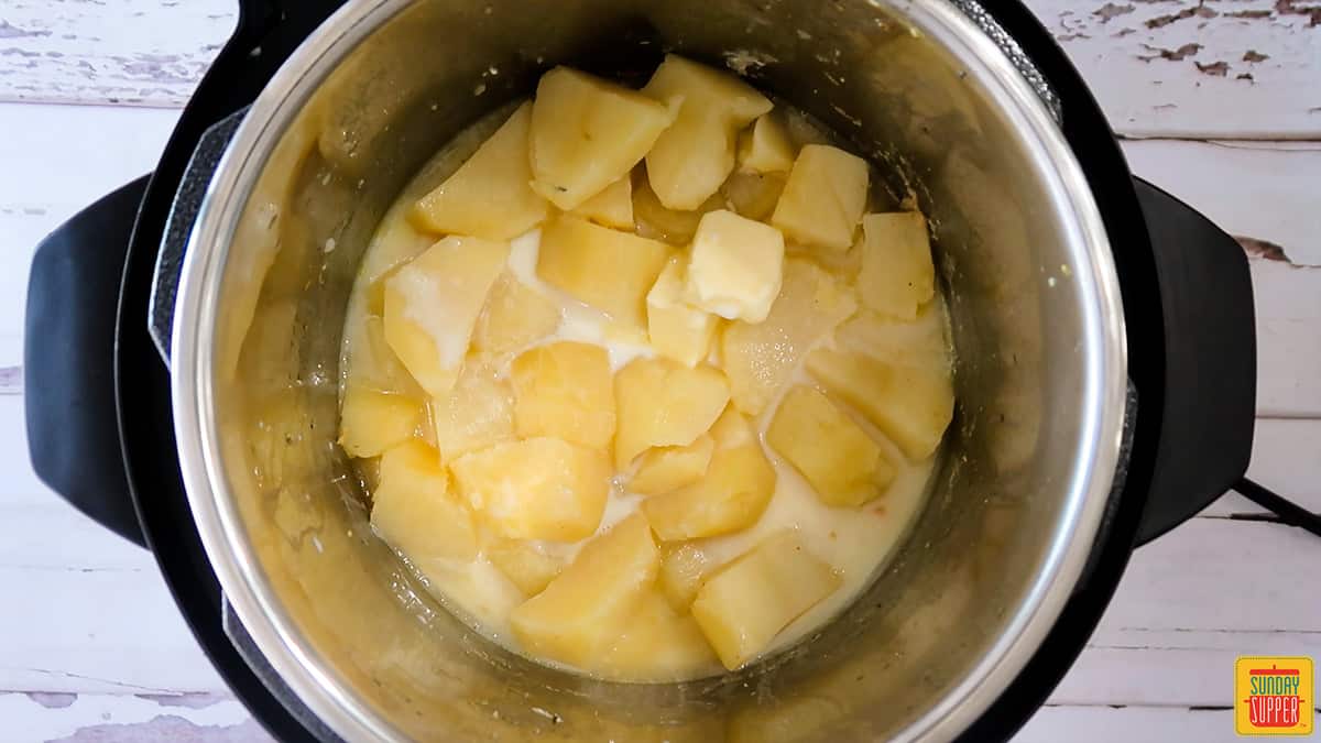 Milk and butter added to the instant pot with the potatoes