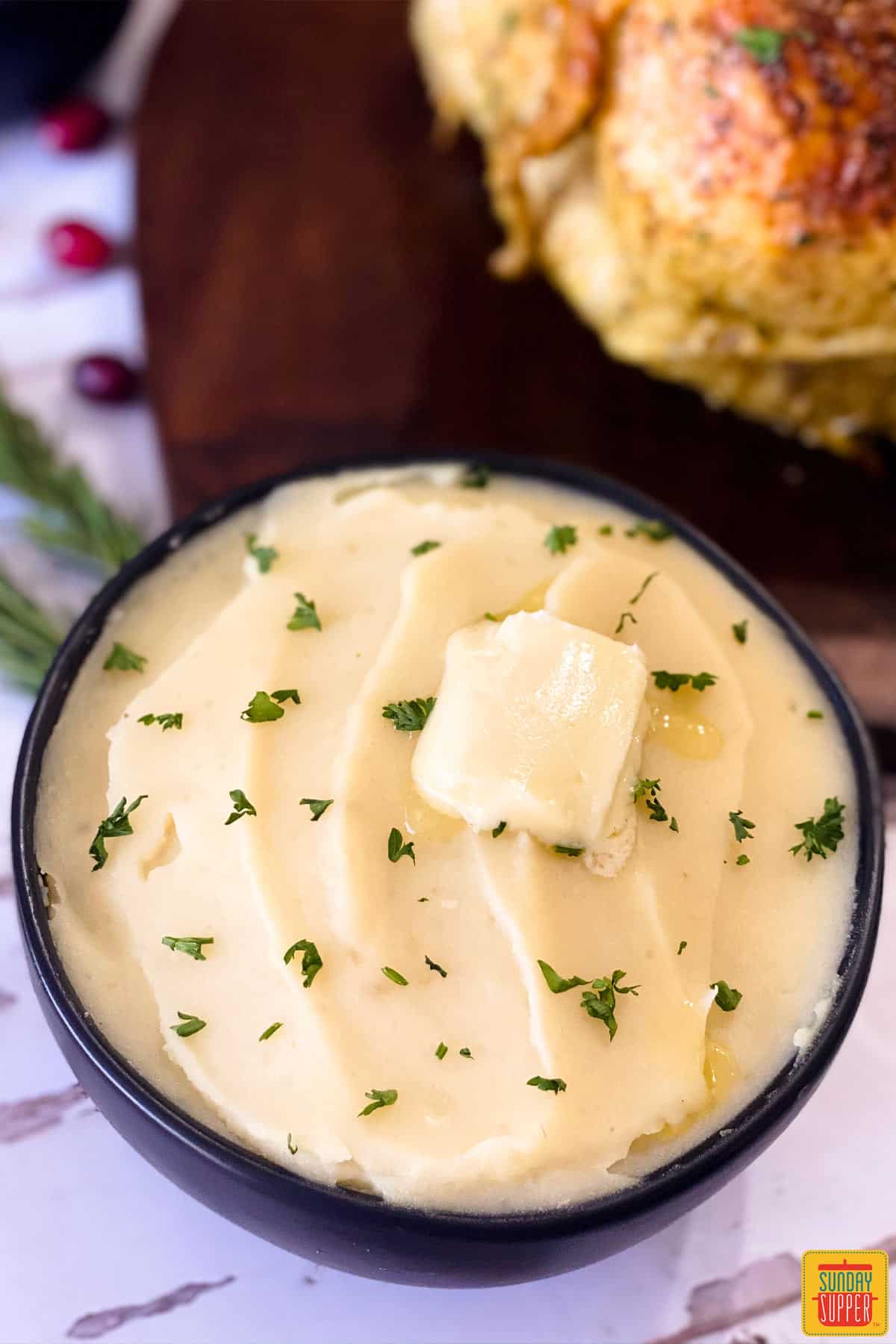 Instant pot mashed potatoes in a black bowl with a pat of butter