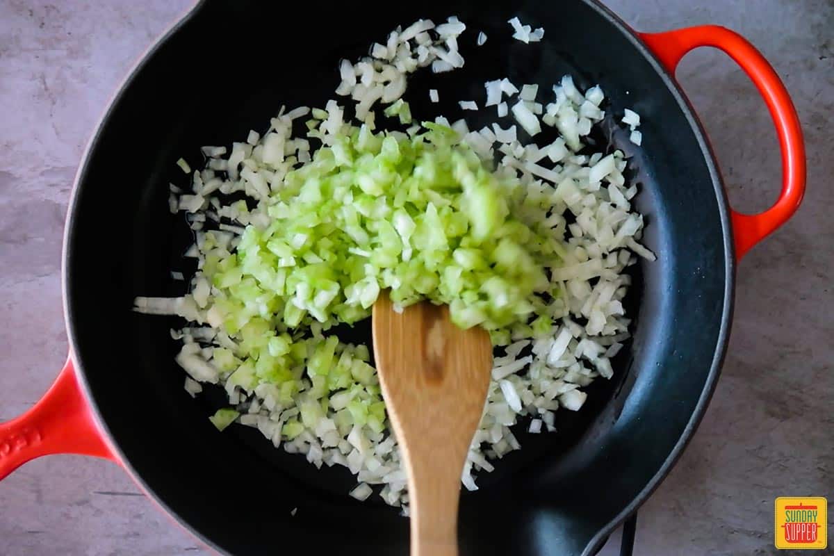 Adding celery to onions in a skillet