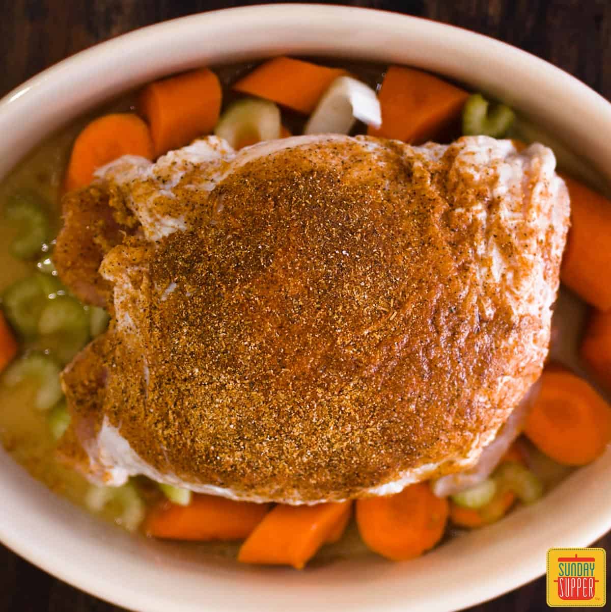 Close up of a turkey in a dutch oven with turkey rub on top