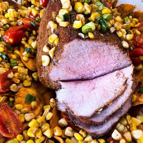 Close up of sliced eye of round roast over corn and tomatoes