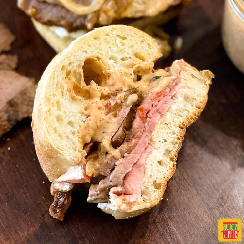 A single hot roast beef sandwich with remoulade sauce ready to eat