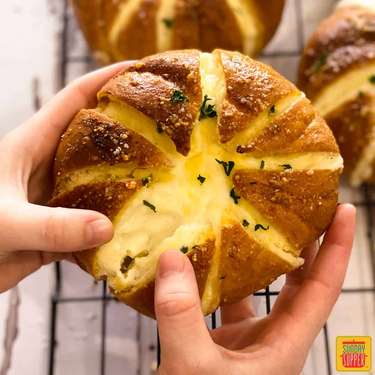 Breaking open a Korean cream cheese garlic roll to show the cheese inside