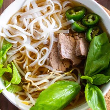 Instant Pot Pho in a white bowl with beef and noodles