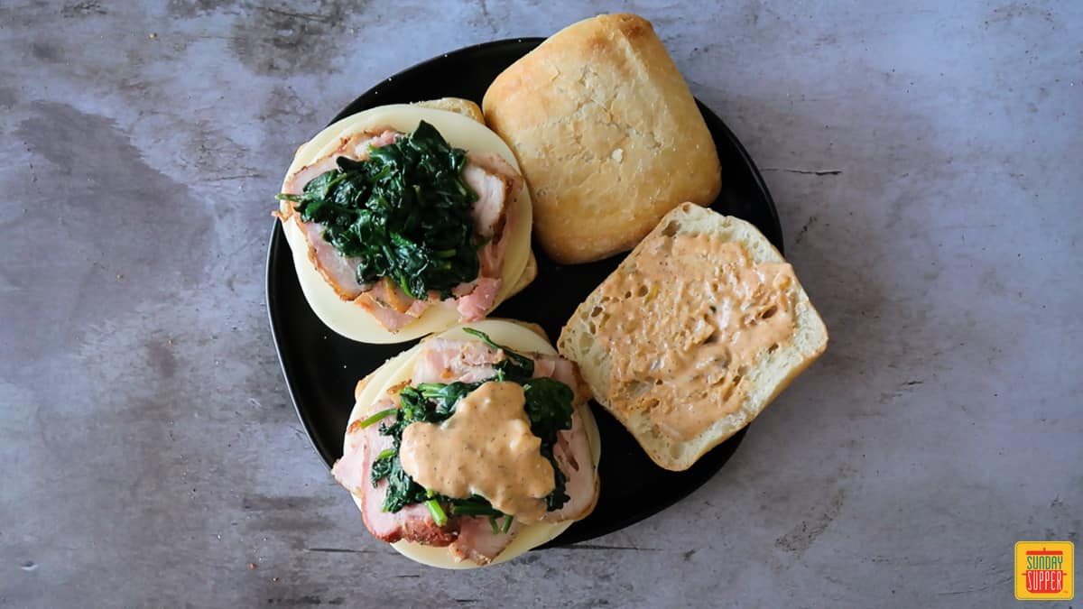 Pork, spinach, and remoulade sauce on buns with provolone cheese