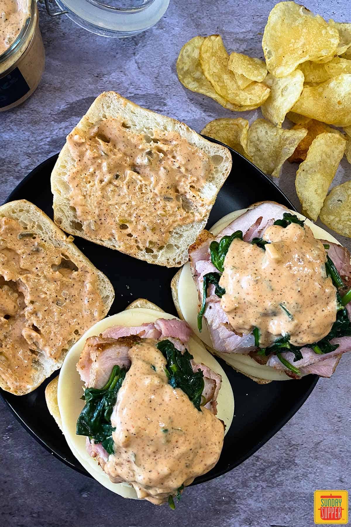 Two pork sandwiches topped with remoulade