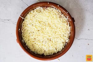 cheese layered in a baking dish for pizza dip