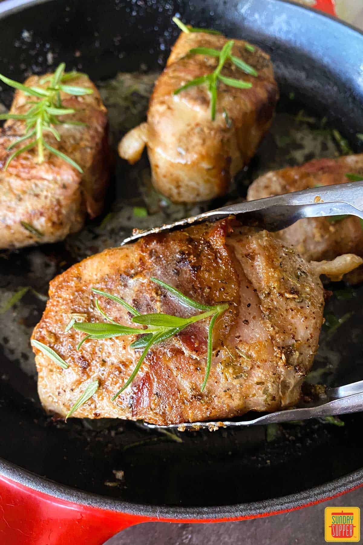 Lifting a sous vide pork chop with tongues