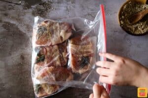 Adding pork chops to a plastic bag