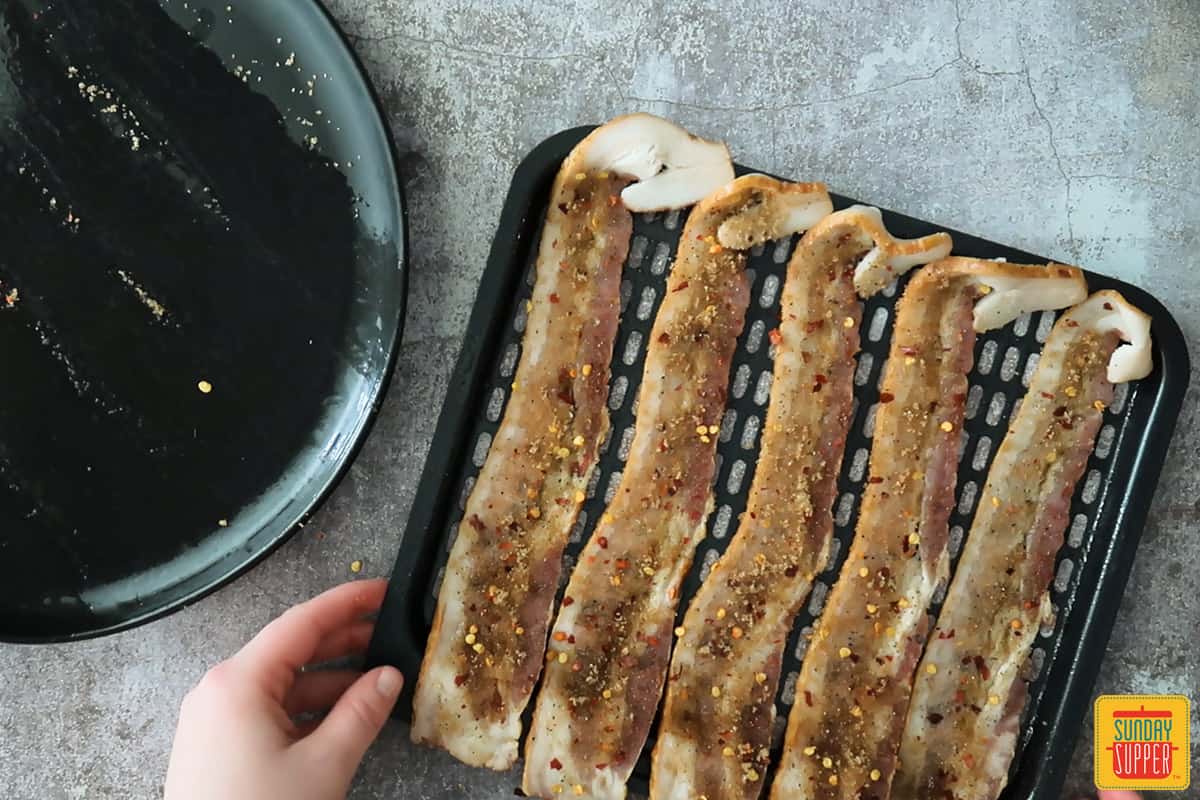 Placing candied bacon on air fryer tray