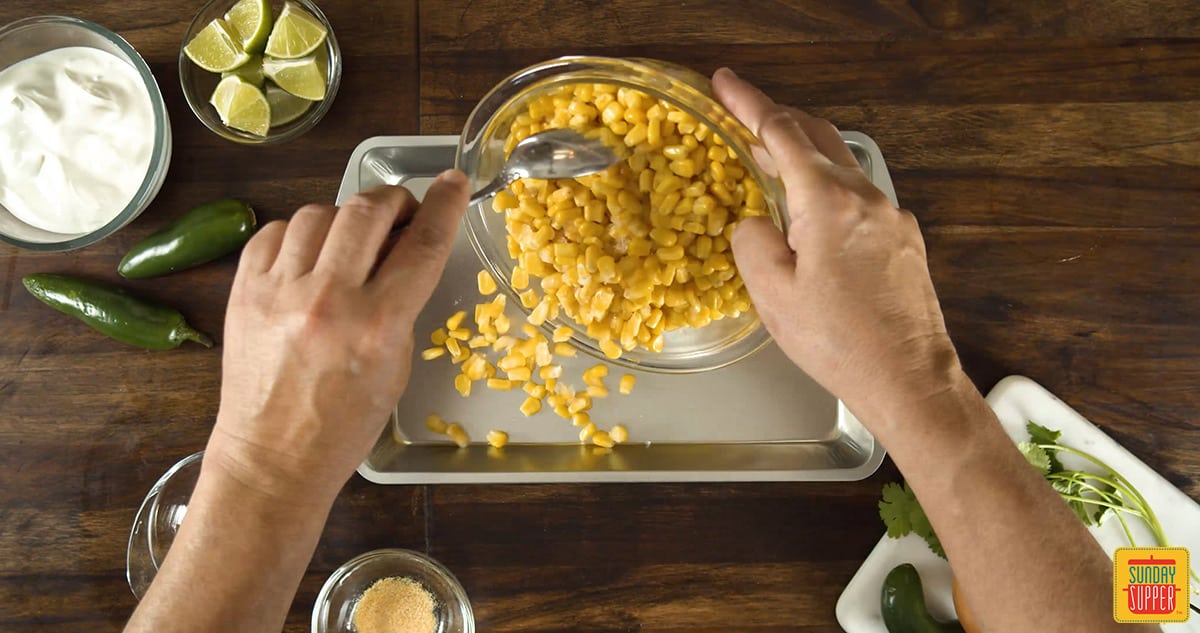 Pouring corn kernels into a dish