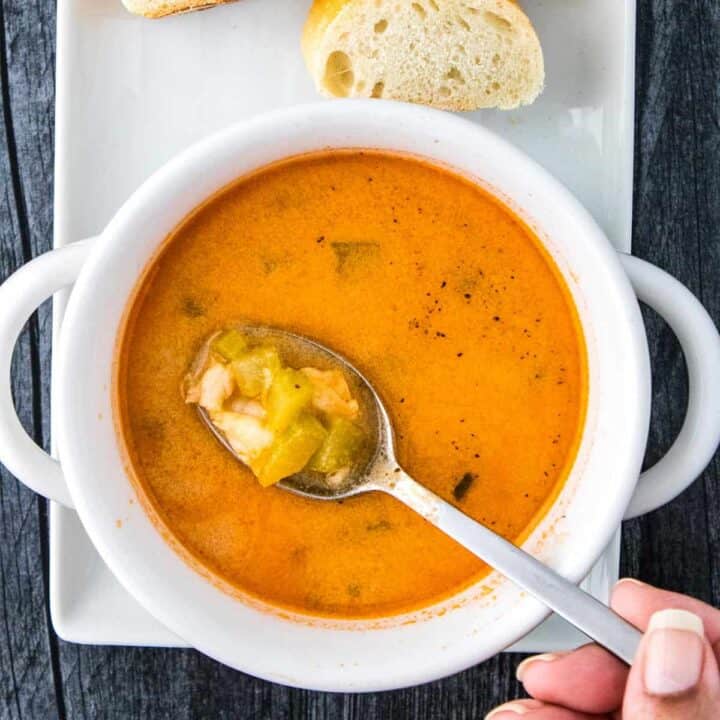 shrimp bisque in a white bowl with a spoonful of bisque over it