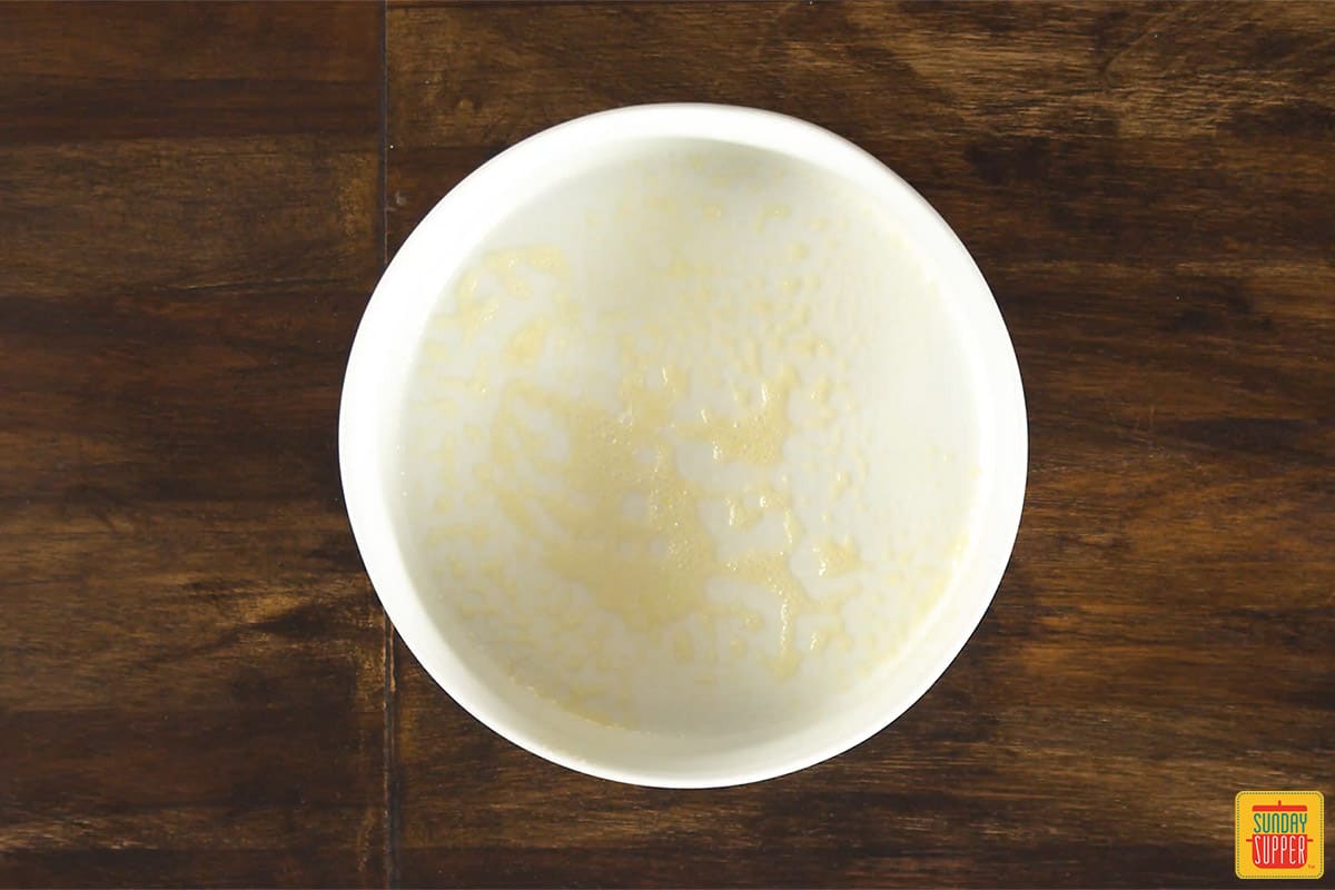 White round baking dish sprayed with cooking spray