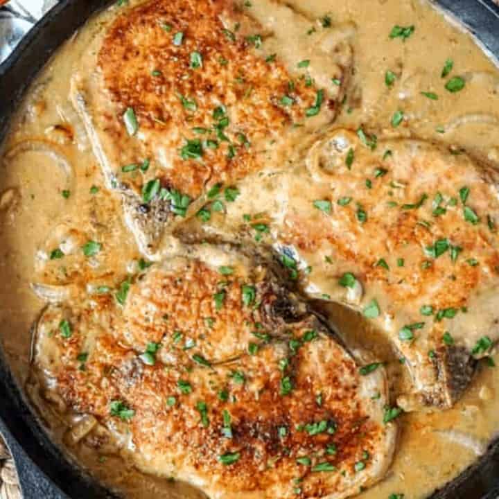 Smothered pork chops in a cast iron skillet