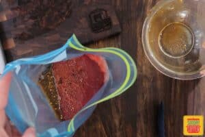 Placing marinade and london broil in a zip-lock bag