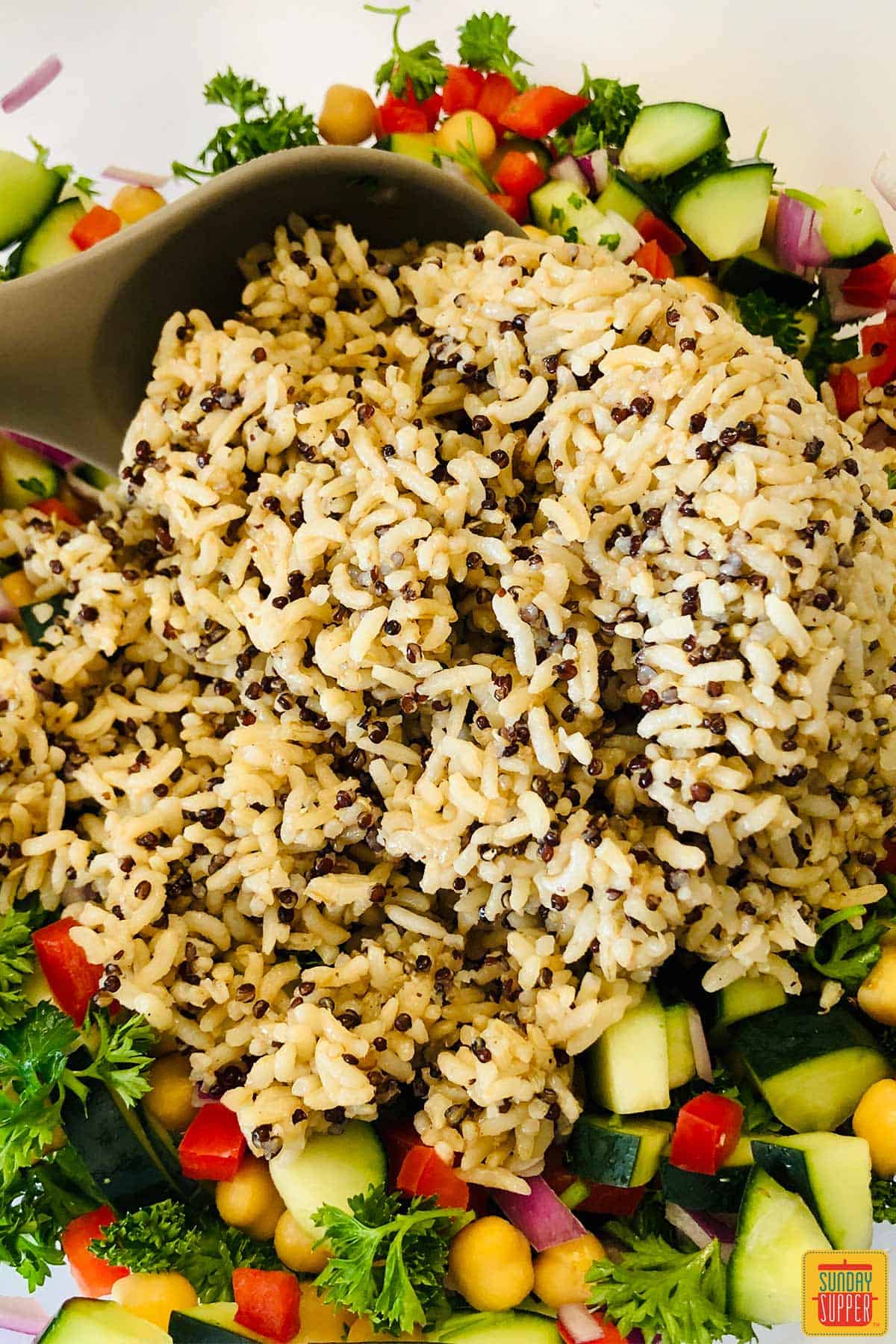 Mixing brown rice into quinoa salad