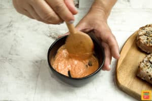 Mixing spicy mayo in a black bowl