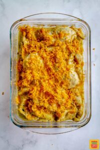 Chicken sprinkled with cheese in baking dish