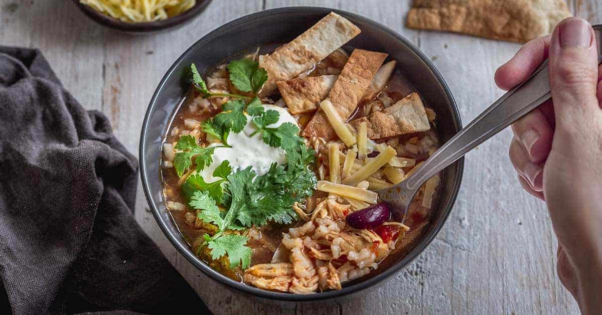 Completed bowl of Mexican Instant Pot chicken rice soup with tortilla strips