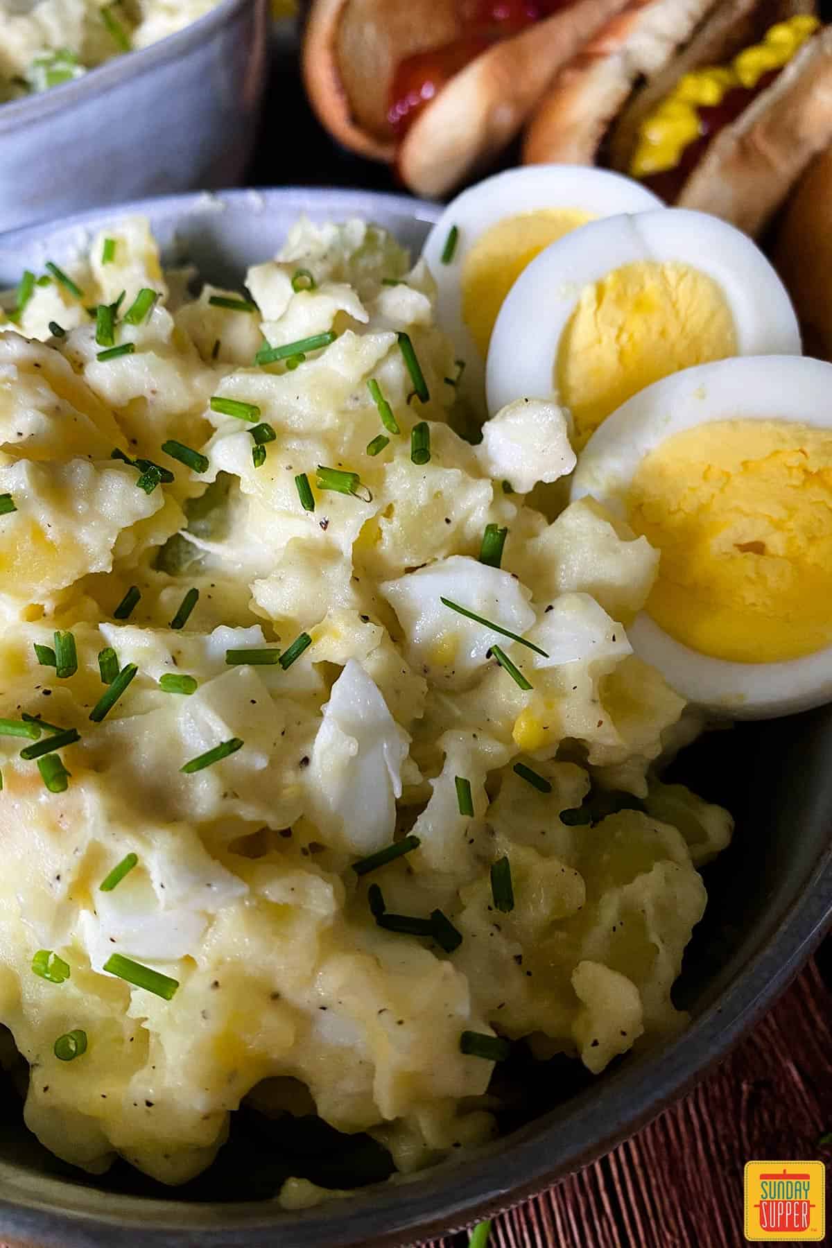close up of instant pot potato salad in a bowl with hard boiled eggs