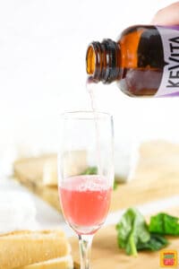 Pouring kombucha into a glass to make cocktails