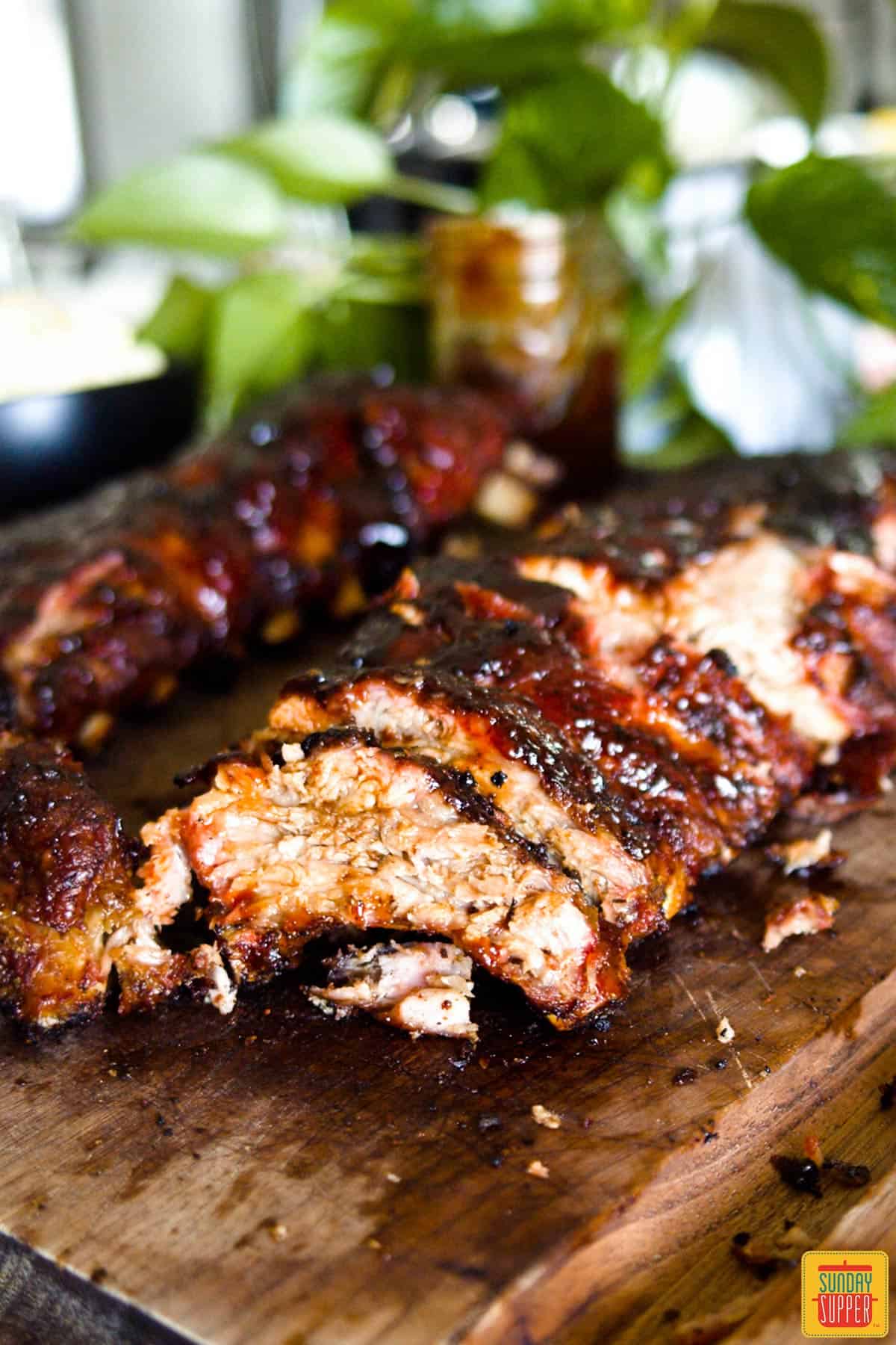 Baby back ribs, cooked with rib rub, on a cutting board