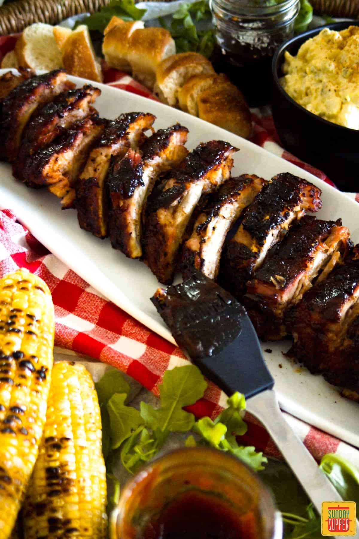 Baby Back Ribs on a white platter with corn