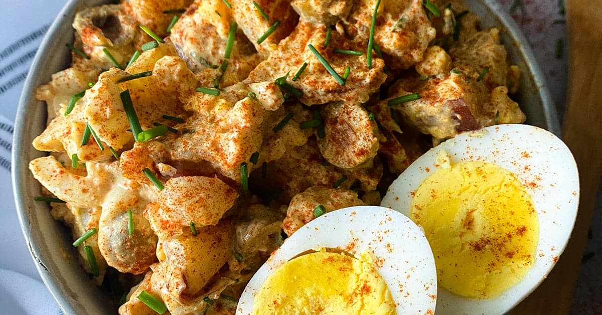 Spanish potato salad with two hard-boiled egg halves on a bowl