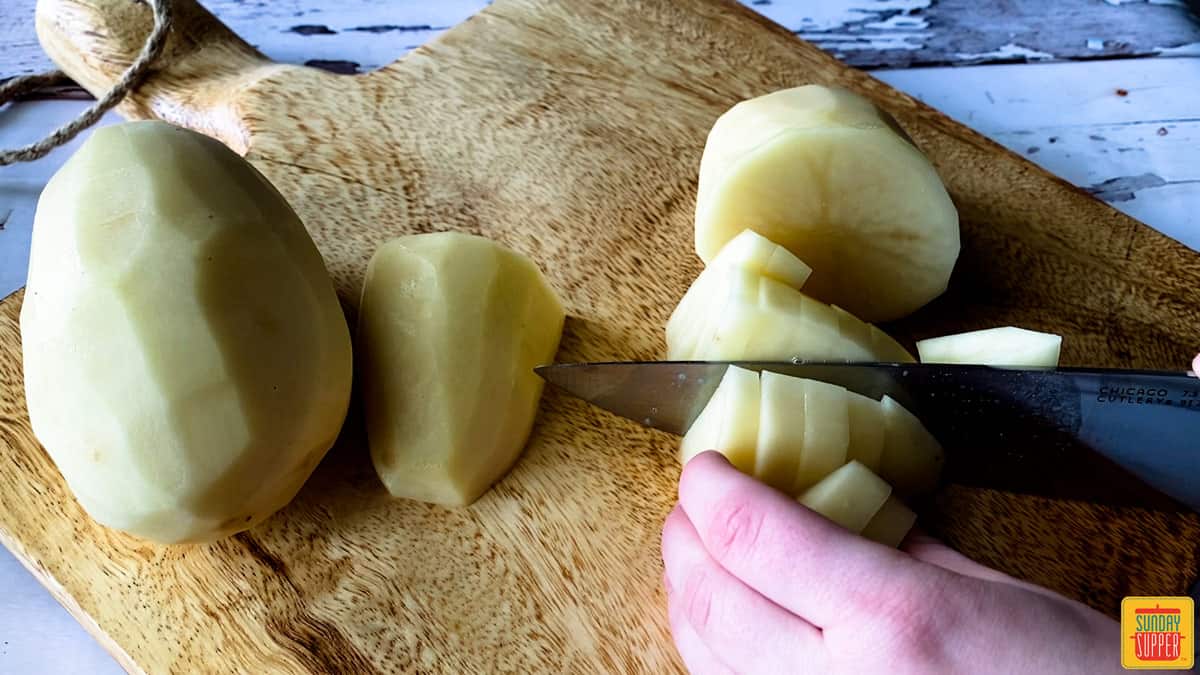 dicing a russet potato on a cutting board